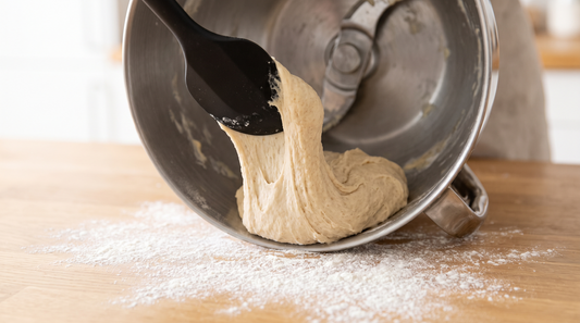 Spatel löst Teig aus Mixtopf mit zentralem Messer